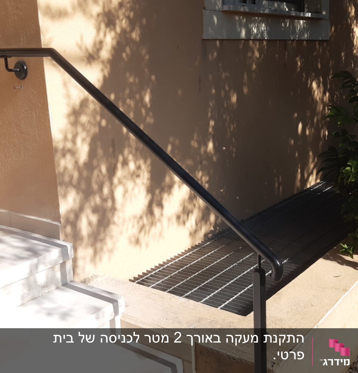 מעקה מתכת שחור ליד מדרגות ובית